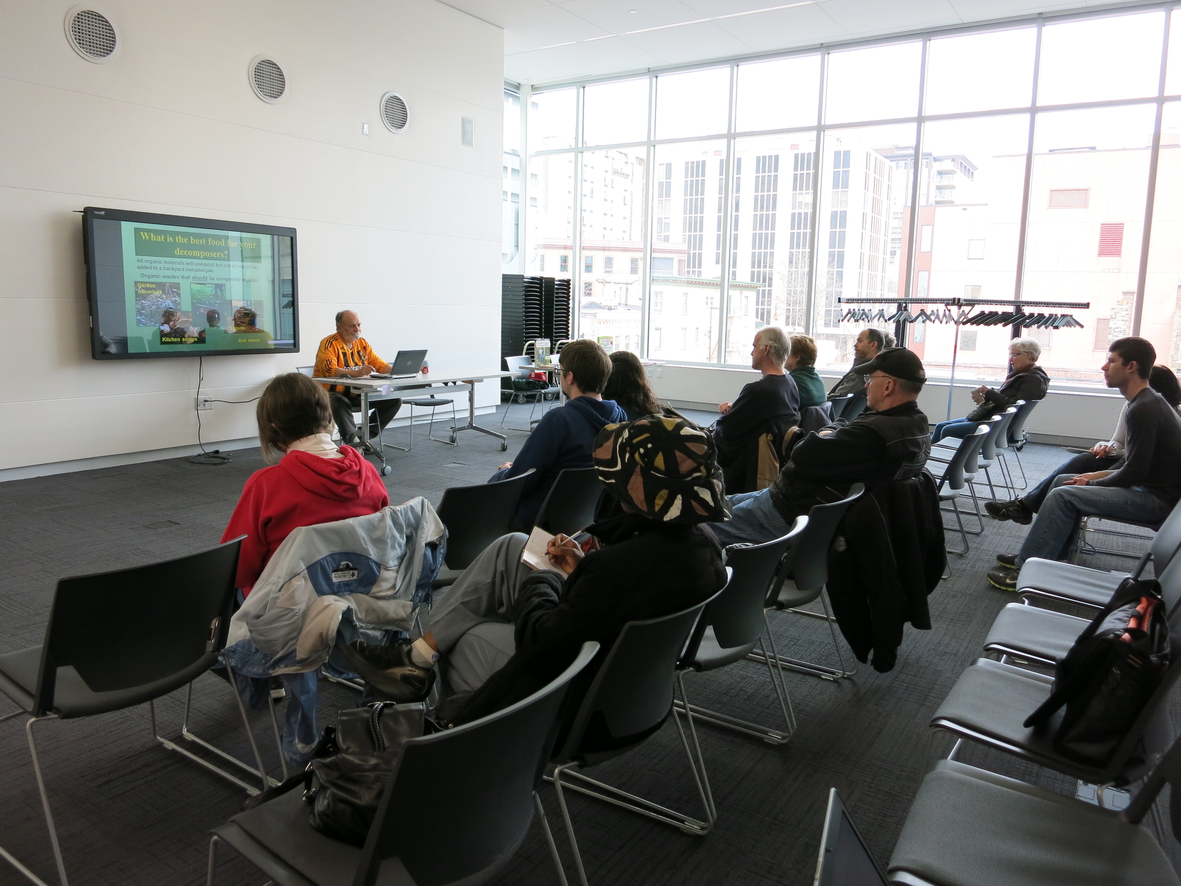 People sitting in rows watching a presentation on a TV
