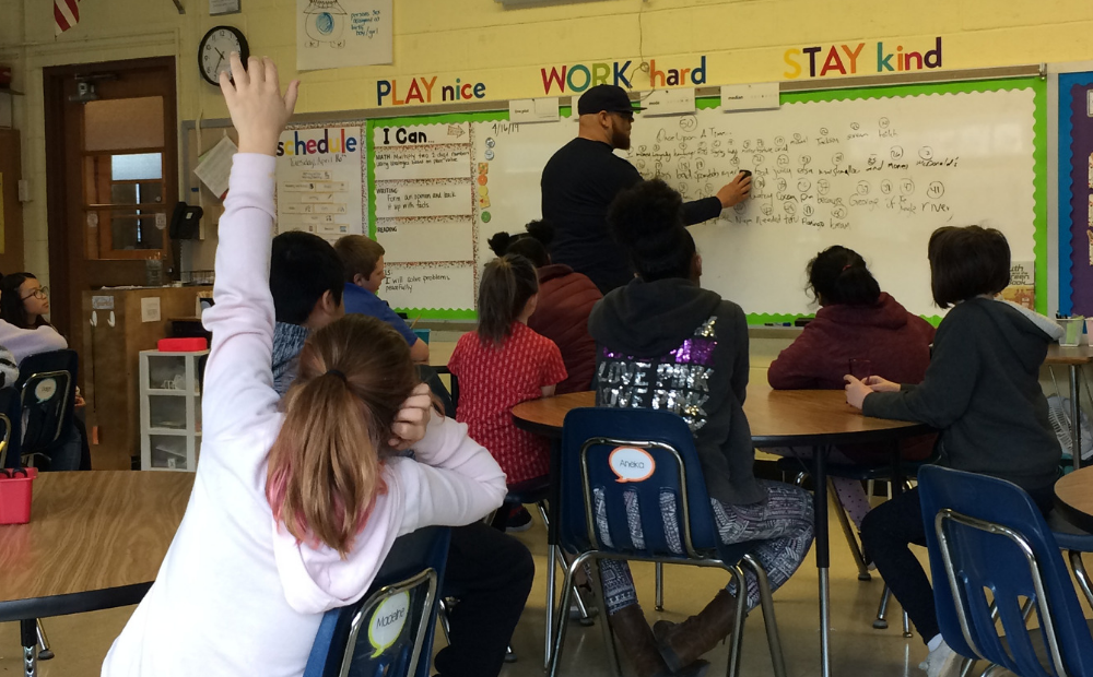 Rob Franklin leads Schenk 4th graders in a 50-word story exercise Library staff at whiteboard teaching class