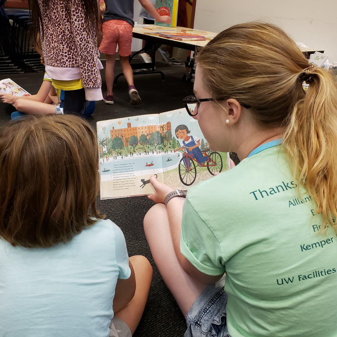 A child reads with an adult during Arts in the Alley A child reads with an adult during Arts in the Alley