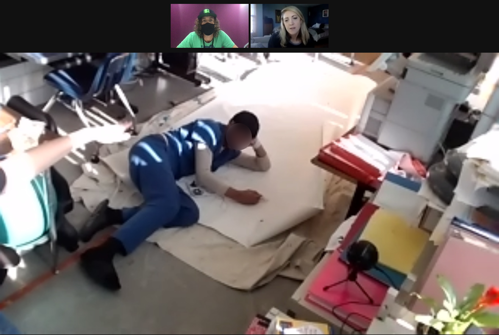 Zoom painting sessions worked! Picture of student working on mural canvas in jail classroom while connected to the artist on zoom.