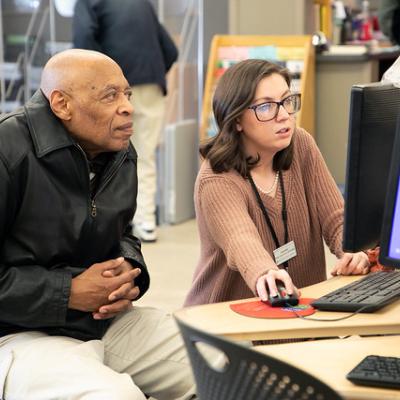 Librarian helping patron at computer Computer training