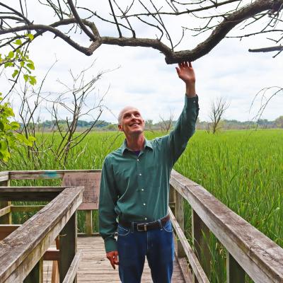 Naturalist Press Photo 1 Vertical.jpg Madison Public Library Naturalist-in-Residence John C. Newman stands among the trees with a prairie in the background at the UW Arboretum