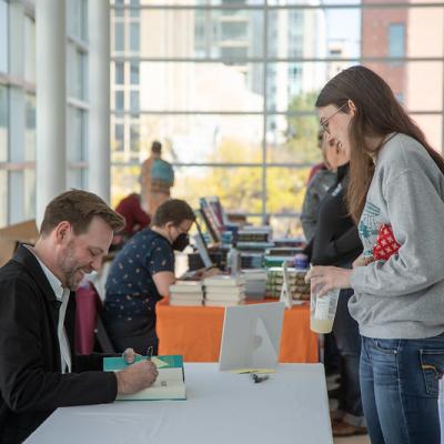 smiling reader getting a book signed by the author