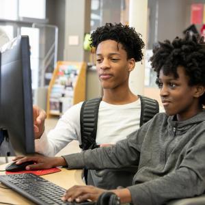 two teens at a computer