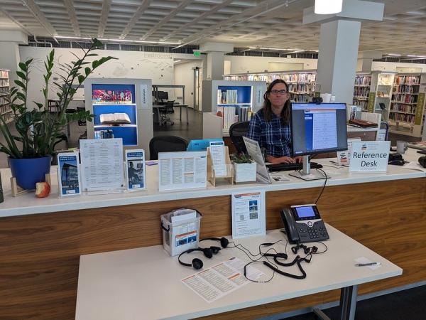 Friendly librarian waiting for questions at the Reference Desk