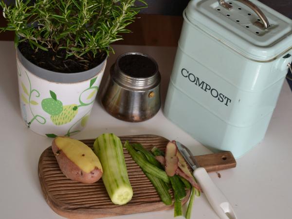 Photo of partially-cut vegetables next to a cute little container labeled &quot;Compost,&quot; courtesy of Lenka Dzurendova on Unsplash