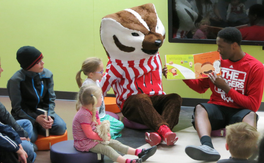Bucky Badger and a UW Athlete read to kids at the library
