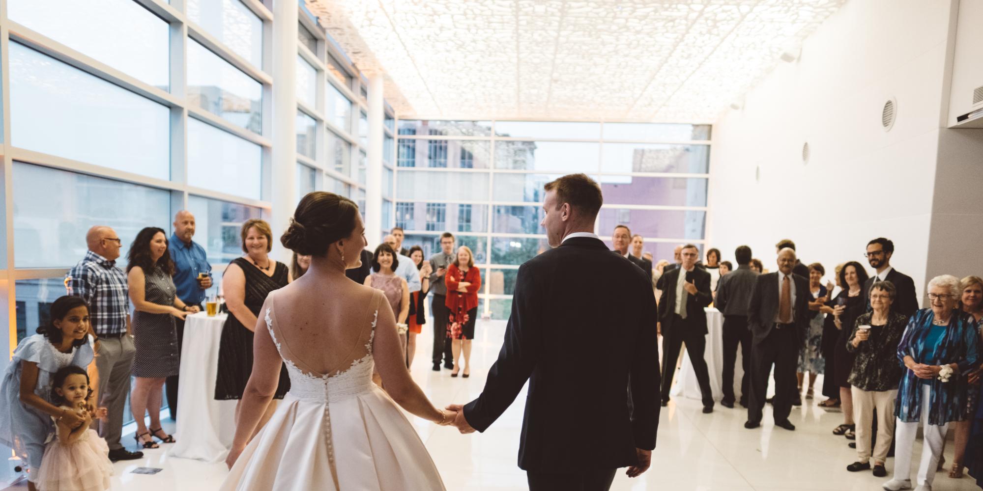 bride and groom entering dance floor in front of wedding guests
