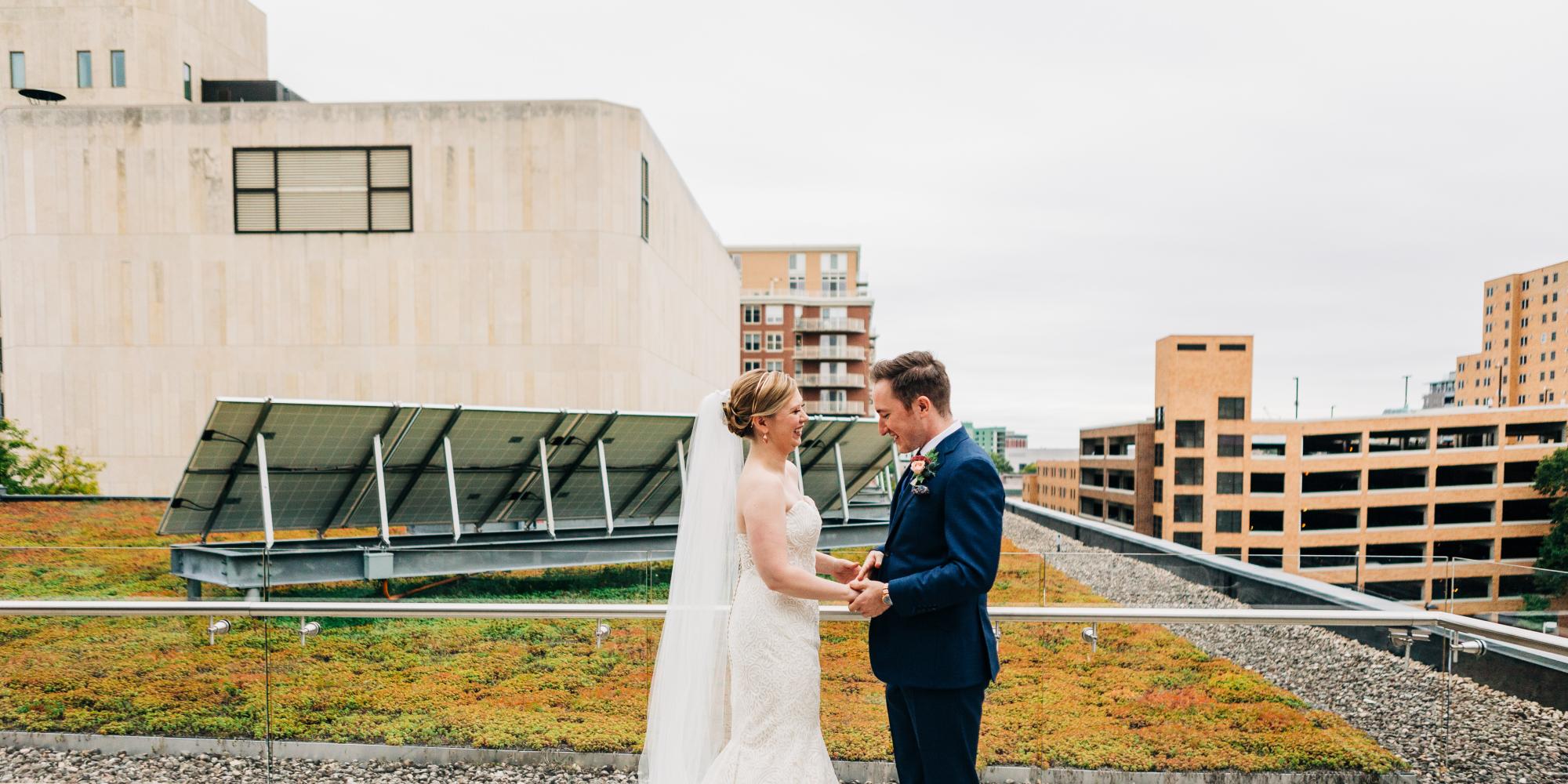 bride and groom posing in front of green roof