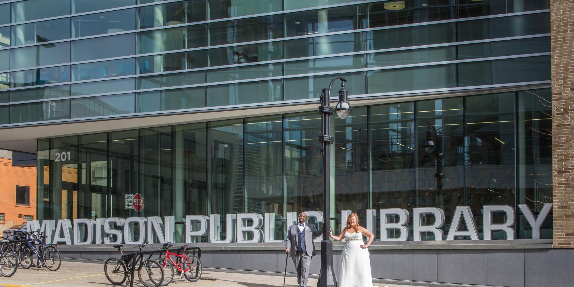 Bride & Groom posing in front of Madison Public Library Sign