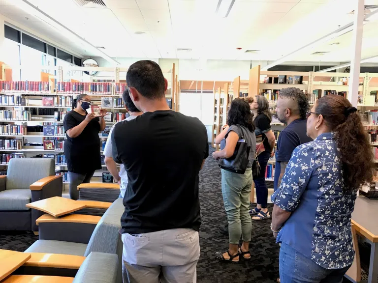 A group Literacy Network students learning from an instructor in the library