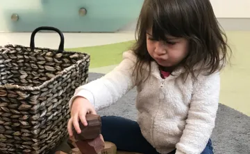 Wonder of Learning Child plays with wooden blocks