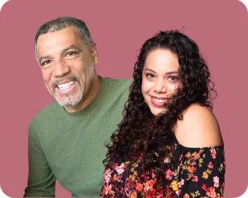 Shelene and Hiram pose together, smiling, in front of a rose colored background Shelene and Hiram pose together, smiling, in front of a rose colored background