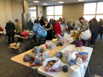 A photo of fiber arts materials and people browsing through them in the Sequoya community room A photo of fiber arts materials and people browsing through them in the Sequoya community room