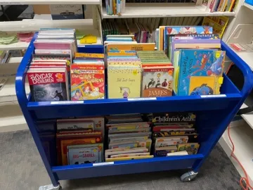 Blue library cart full of children's books