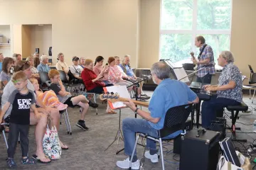 A three-piece band plays to a crowd indoors at Sequoya Library