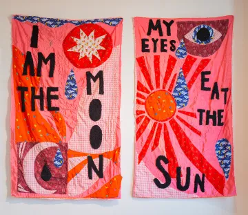 two fabric banners with text that read "I am the moon my eyes eat the sun" two fabric banners with text that read "I am the moon my eyes eat the sun"