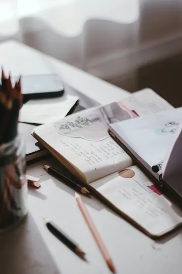 Table with open journal and a pen and pencil Table with open journal and a pen and pencil
