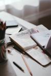 Table with open journal and a pen and pencil Table with open journal and a pen and pencil